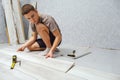 Young man is laying wooden panel of laminate floor indoors. Royalty Free Stock Photo