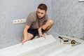 Young man is laying wooden panel of laminate floor Royalty Free Stock Photo