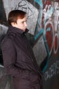 Young man leans back on wall with graffiti Royalty Free Stock Photo