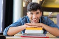 Young man leans on stack of books Royalty Free Stock Photo