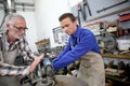 Young man learning ironworks with instructor