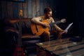 Young man learning play guitar at home