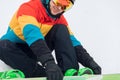 Young man learning to put on snowboard Royalty Free Stock Photo