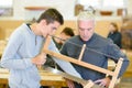 young man learns from luthier master in saw lesson Royalty Free Stock Photo