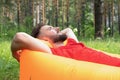 young man lies on an air mattress, smiles, dreams and rests. traveler is resting in nature Royalty Free Stock Photo