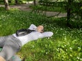 A young man lies on a chamomile meadow, rests, meditates. Summer sunny day. Royalty Free Stock Photo