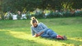 Young man lies on grass and uses phone. Concept. Stylish man with beard rests with phone lying on green grass in park Royalty Free Stock Photo