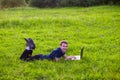 Young man lies on green grass with laptop and working Royalty Free Stock Photo