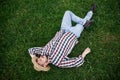 A young man lies on the green grass and rests on a summer day Royalty Free Stock Photo