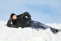 Young man lies on snow support palm Royalty Free Stock Photo