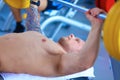 Young man lifting the barbell in gym with instructor Royalty Free Stock Photo