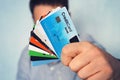 Young man in light blue shirt showing many types of credit cards. Businessman in casual wear holding in hand various payment cards Royalty Free Stock Photo