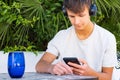 Cute teen boy listening to music on headphones in his phone Royalty Free Stock Photo