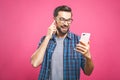 Young man listening music in headphones and dancing over pink background. Isolated Royalty Free Stock Photo