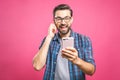 Young man listening music in headphones and dancing over pink background. Isolated Royalty Free Stock Photo