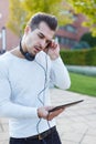 Young man listening music on tablet outdoor Royalty Free Stock Photo