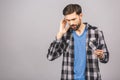 Young man listening music using phone and dancing over grey background. Isolated Royalty Free Stock Photo