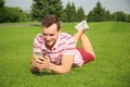 Young man listening to music on green grass outdoors Royalty Free Stock Photo