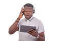 Young young man listening to music with headphones on a digital tablet