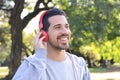 Young man listening to music with headphones in park. Royalty Free Stock Photo