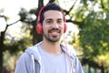 Young man listening to music with headphones in park. Royalty Free Stock Photo