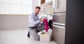 Young Man Loading Clothes Into Washing Machine Royalty Free Stock Photo