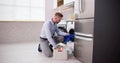 Young Man Loading Clothes Into Washing Machine Royalty Free Stock Photo