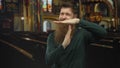 Young man with long beard makes timeout gesture inside a dimly lit church building; serenity reflection Royalty Free Stock Photo