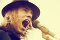 Young man with long hair and hat shouting to microphone. Vintage, music Royalty Free Stock Photo