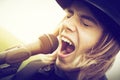 Young man with long hair and hat singing to microphone. Vintage, music Royalty Free Stock Photo