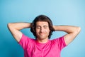 Young man look satisfied relaxed hands behind head closed eyes in pink outfit isolated on blue color background Royalty Free Stock Photo