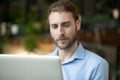 Young man looking calmly and positively at laptop screen. Royalty Free Stock Photo