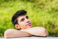 Young man looking at camera outdoor, leaning with Royalty Free Stock Photo