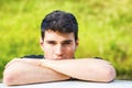 Young man looking at camera outdoor, leaning with Royalty Free Stock Photo