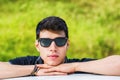 Young man looking at camera outdoor, leaning with Royalty Free Stock Photo