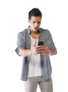 Young man looking at cell phone with angry expression Royalty Free Stock Photo