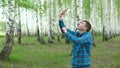A young man is looking for a cellular network in a birch forest. A man is talking on the phone, but the connection is Royalty Free Stock Photo