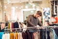 A young man looking through the clothes on a rail, a scene at a clothing department Royalty Free Stock Photo