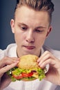 Young man looking at a fresh burger Royalty Free Stock Photo