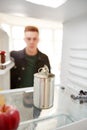 Young Man Looking Inside Refrigerator Empty Except For Open Tin Can On Shelf Royalty Free Stock Photo
