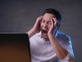 Young Man Looking at Laptop, Angry Gesture