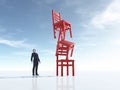 Young man looking at three chairs in equilibrium