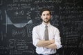 Young man looking to camera in front of a blackboard Royalty Free Stock Photo