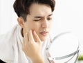 Young man looking to mirror and squeezing pimple Royalty Free Stock Photo