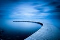 Young man looking to sea on curved jetty