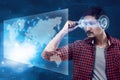 Young man looking world map with futuristic smart high tech glasses Royalty Free Stock Photo