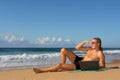 Young man looks far lying with notebook