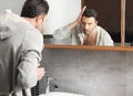 Man looks at himself in the mirror