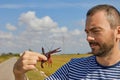 A young man looks at a red swamp crayfish caught in a rice field Royalty Free Stock Photo