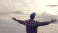 A young man looks into the sky,hands are on the side,the guy pretends to be an airplane, a beautiful landscape and the silhouette